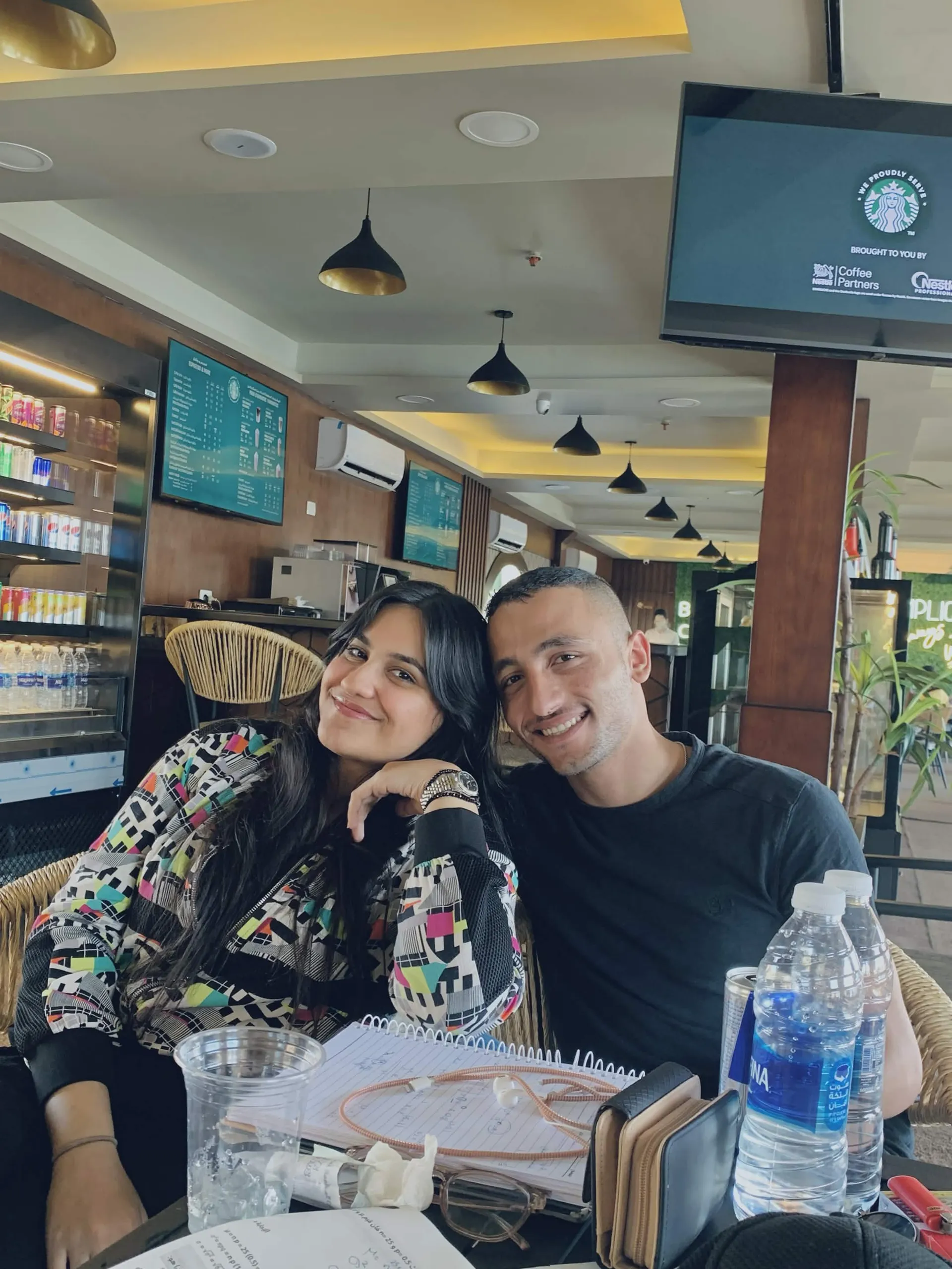 Muhammed and Merna sharing a quiet moment at a café